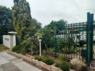 a green fence with plants in a garden at Urban Oasis Cape Town in Cape Town