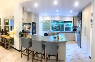 a kitchen with an island with chairs and an aquarium at Regent Casa's - Cape Towns Blouberg Area - Where 20 people can stay in Cape Town