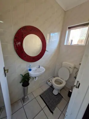 a bathroom with a toilet and a sink and a mirror at Regent Casa's - Cape Towns Blouberg Area - Where 20 people can stay in Cape Town