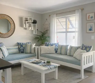 a living room with two couches and a table at Serenity self-catering 2-bed unit in Hermanus