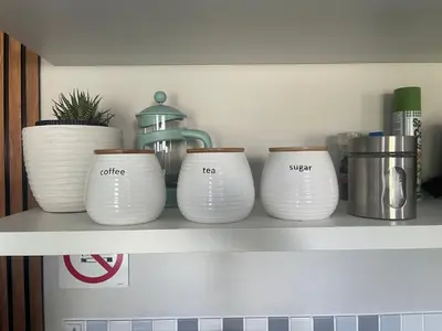 a shelf with four white vases on it at Serenity self-catering 2-bed unit in Hermanus