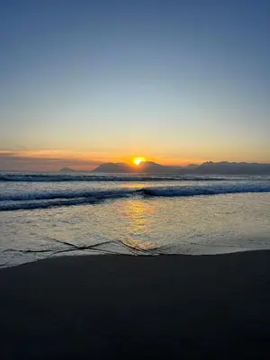 a sunset on a beach with the ocean at Serenity self-catering 2-bed unit in Hermanus