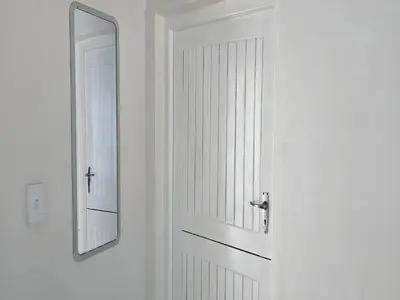 a white door with a mirror on a wall at Goshen Lodge Spencer in Cape Town