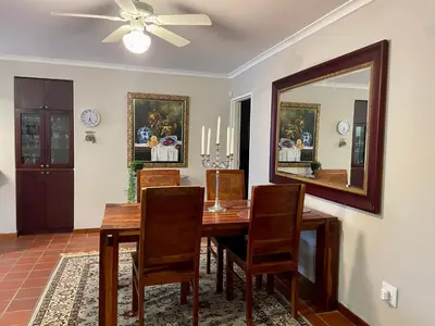 a dining room with a table and a mirror at Lakeview Cottage: Rural Retreat in Pampoenkraal