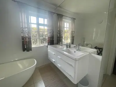 a white bathroom with a sink and a tub and a toilet at Lakeview Cottage: Rural Retreat in Pampoenkraal