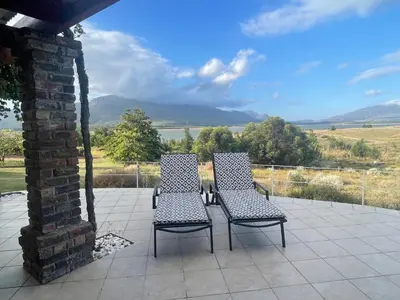 two chairs and a table on a patio with a view at Lakeview Cottage: Rural Retreat in Pampoenkraal