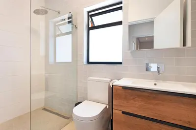 a bathroom with a toilet and a sink and a window at The Baydreamer, where the view soothes your soul in Pringle Bay