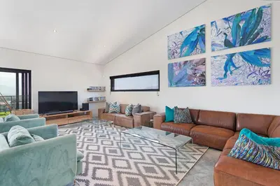 a living room with couches and a flat screen tv at The Baydreamer, where the view soothes your soul in Pringle Bay