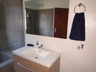 a bathroom with a sink and a shower and a mirror at 105 on Sarel Cilliers in Strand