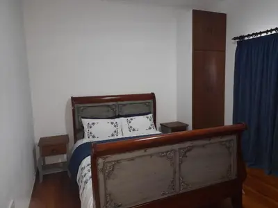 a bedroom with a bed and a blue curtain at 105 on Sarel Cilliers in Strand