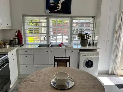 a kitchen with a table with a cup on a plate at Somerset West All Stay 2 in Somerset West