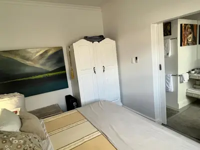 a bedroom with a bed and a white cabinet at Somerset West All Stay 2 in Somerset West