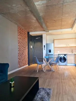 an open living room with a table and chairs at Matrix by Smart City Stays in Cape Town