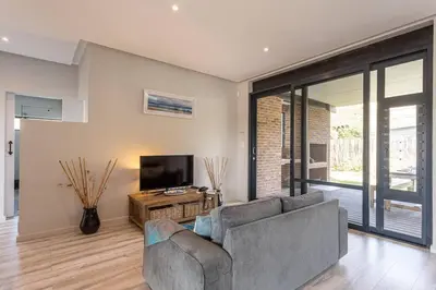 a living room with a couch and a television at Pringle Bay getaway - 2 bedroom garden apartment in Pringle Bay