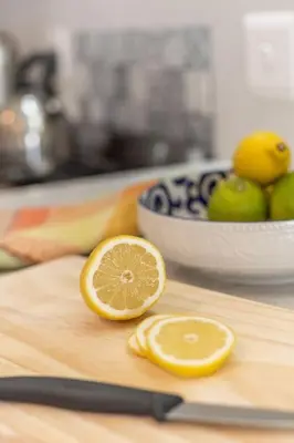 a cutting board with two lemons and a bowl of apples at Pringle Bay getaway - 2 bedroom garden apartment in Pringle Bay