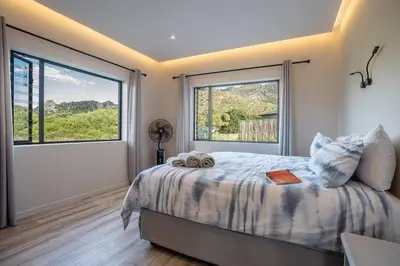 a bedroom with a bed and a large window at Pringle Bay getaway - 2 bedroom garden apartment in Pringle Bay