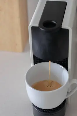 a cup of coffee is coming out of a coffee maker at Spacious, Modern & Convenient in Franschhoek