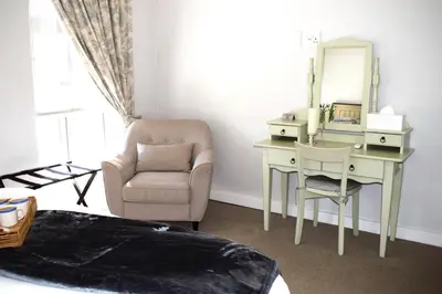 a bedroom with a desk and a chair and a mirror at Spacious, Modern & Convenient in Franschhoek