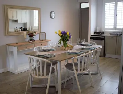a kitchen with a table and chairs with flowers on it at Spacious, Modern & Convenient in Franschhoek