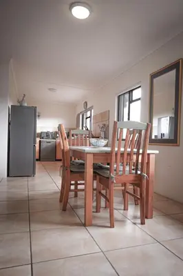 a kitchen with a wooden table with chairs and a refrigerator at 31 on Witzenberg, Tulbagh in Wolseley