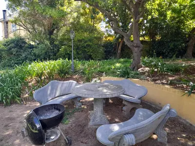 a table and two chairs and a table and a tree at Lovely Concordia, rental unit with free parking in Cape Town