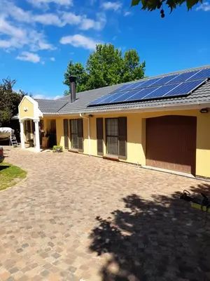 a house with solar panels on the roof at Lovely Concordia, rental unit with free parking in Cape Town