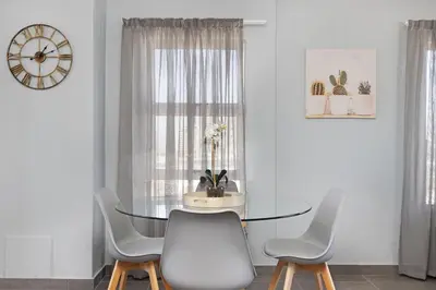 a dining room with a glass table and chairs at Ocean View 503 in Bloubergstrand
