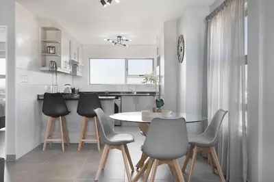 a dining room with a table and chairs in a kitchen at Ocean View 503 in Bloubergstrand