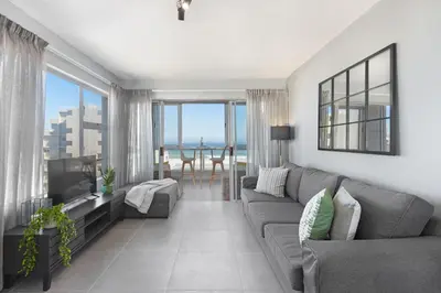 a living room with a couch and a television at Ocean View 503 in Bloubergstrand