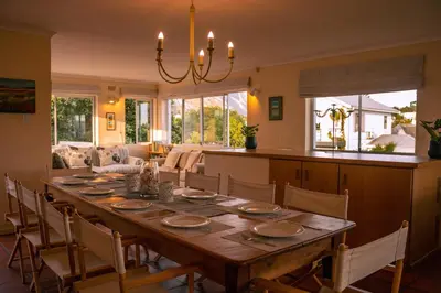 a dining room with a large wooden table with chairs at The Mountainview Family Retreat in Hermanus