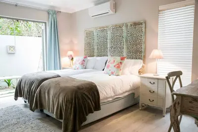 a bedroom with a large bed and a window at 13 La Gratitude Luxury Apartment-with backup power for loadshedding in Stellenbosch