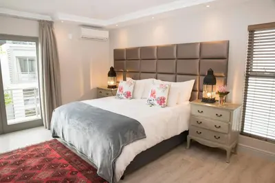 a bedroom with a large bed with a large headboard at 13 La Gratitude Luxury Apartment-with backup power for loadshedding in Stellenbosch