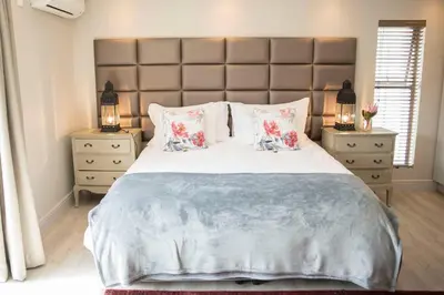 a bedroom with a large bed with two night stands at 13 La Gratitude Luxury Apartment-with backup power for loadshedding in Stellenbosch