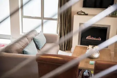 a living room with a couch and a fireplace at 13 La Gratitude Luxury Apartment-with backup power for loadshedding in Stellenbosch