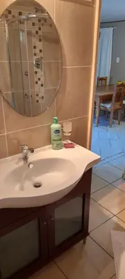 a bathroom with a sink and a mirror at Lovely Kaapgracht, rental unit with free parking in Cape Town
