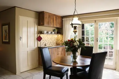 a kitchen with a table with chairs and a vase of flowers at Lovely Kaapgracht, rental unit with free parking in Cape Town