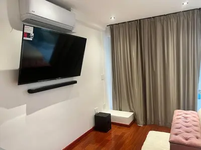 a living room with a flat screen tv on the wall at Amazing! 7 bedroom villa with rooftop pool & views in Cape Town