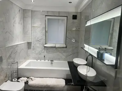 a bathroom with a tub and two toilets and a sink at Amazing! 7 bedroom villa with rooftop pool & views in Cape Town