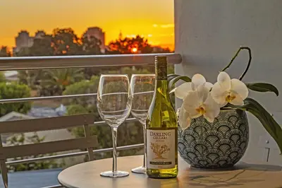 a bottle of wine and two glasses on a table at Atlantic Port 9 by Host Agents in Bloubergstrand