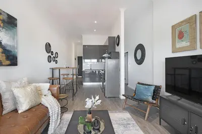 a living room with a couch and a kitchen at Atlantic Port 9 by Host Agents in Bloubergstrand