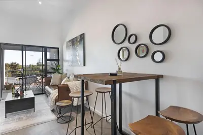 a living room with a table and some stools at Atlantic Port 9 by Host Agents in Bloubergstrand