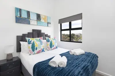 a bedroom with a bed with towels on it at Atlantic Port 9 by Host Agents in Bloubergstrand