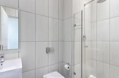 a bathroom with a shower and a toilet and a sink at Atlantic Port 9 by Host Agents in Bloubergstrand