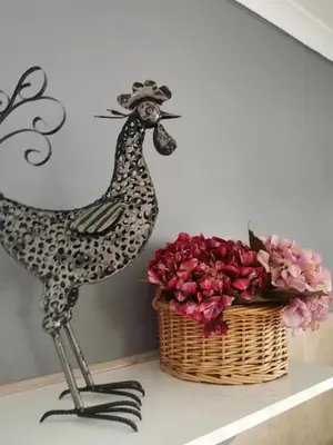 a statue of a chicken next to a basket of flowers at Somerset west Mountain road cottage in Cape Town