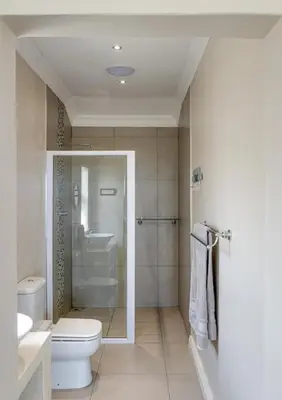 a bathroom with a toilet and a shower and a sink at Seafront Retreat in Sandbaai in Hermanus