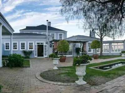 a white house with a courtyard with vases at Faraway Estate in Villiersdorp