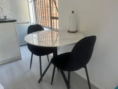 a glass table and two chairs in a kitchen at Charm Nest - Uncapped Wi-fi & Self Check-in in Cape Town