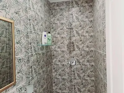 a bathroom with a shower with a black and white wallpaper at Charm Nest - Uncapped Wi-fi & Self Check-in in Cape Town