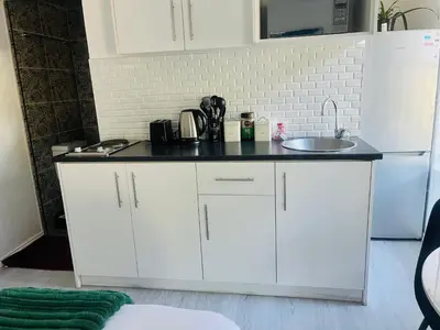a kitchen with a white refrigerator and a sink at Charm Nest - Uncapped Wi-fi & Self Check-in in Cape Town