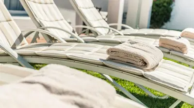 a group of white chairs with towels on them at Avenues Guest House in Stellenbosch